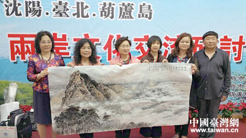 兩岸6名畫家合影展示聯(lián)手繪成的一副山水畫“云海連兩岸,書畫結(jié)同心” 兩岸6名畫家合影展示聯(lián)手繪成的一副山水畫“云海連兩岸,書畫結(jié)同心”