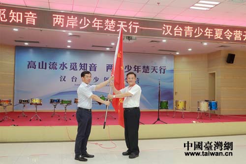 武漢市人民政府副市長(zhǎng)盧沙野(左)向臺(tái)灣苗栗縣泰安鄉(xiāng)鄉(xiāng)長(zhǎng)柯武勇授營(yíng)旗